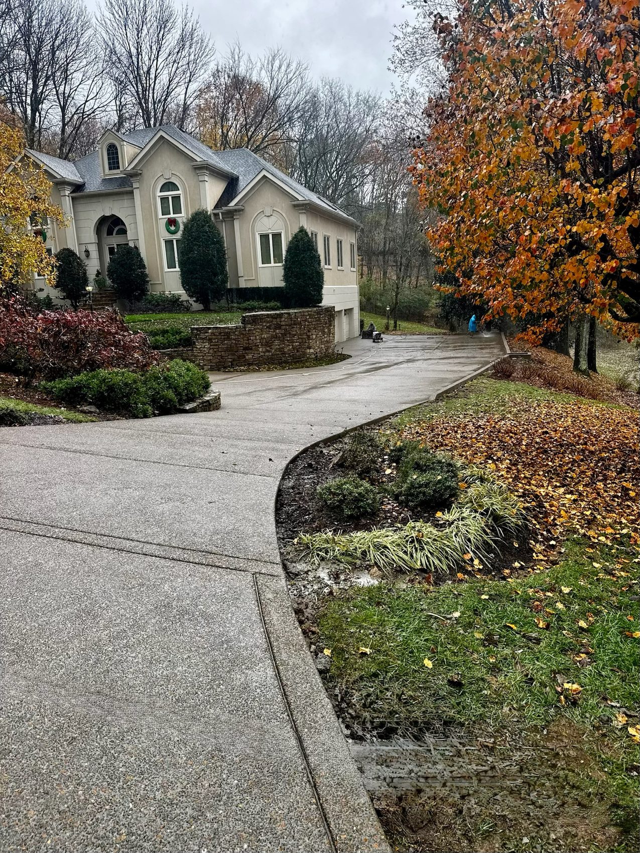 New driveway in a washed exposed-aggregate finish curving up to a stucco home in Forest Hills