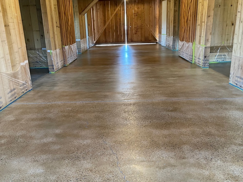 Center aisle of a Leiper's Fork barn, the floor stained a warm variegated tan and sealed