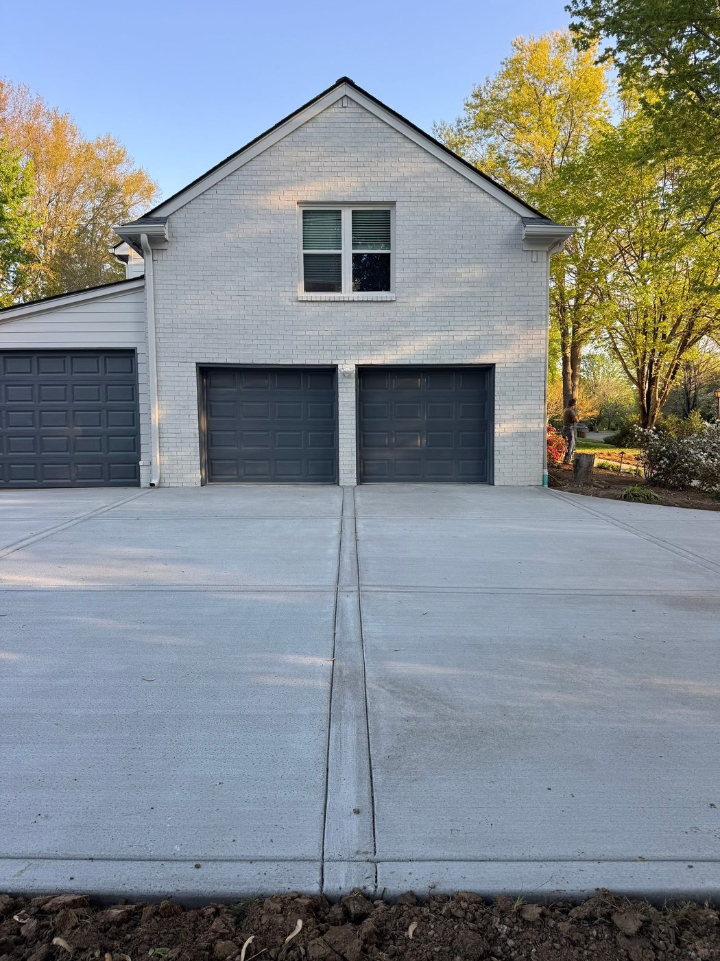 New poured concrete driveway in Nashville in front of a white brick home